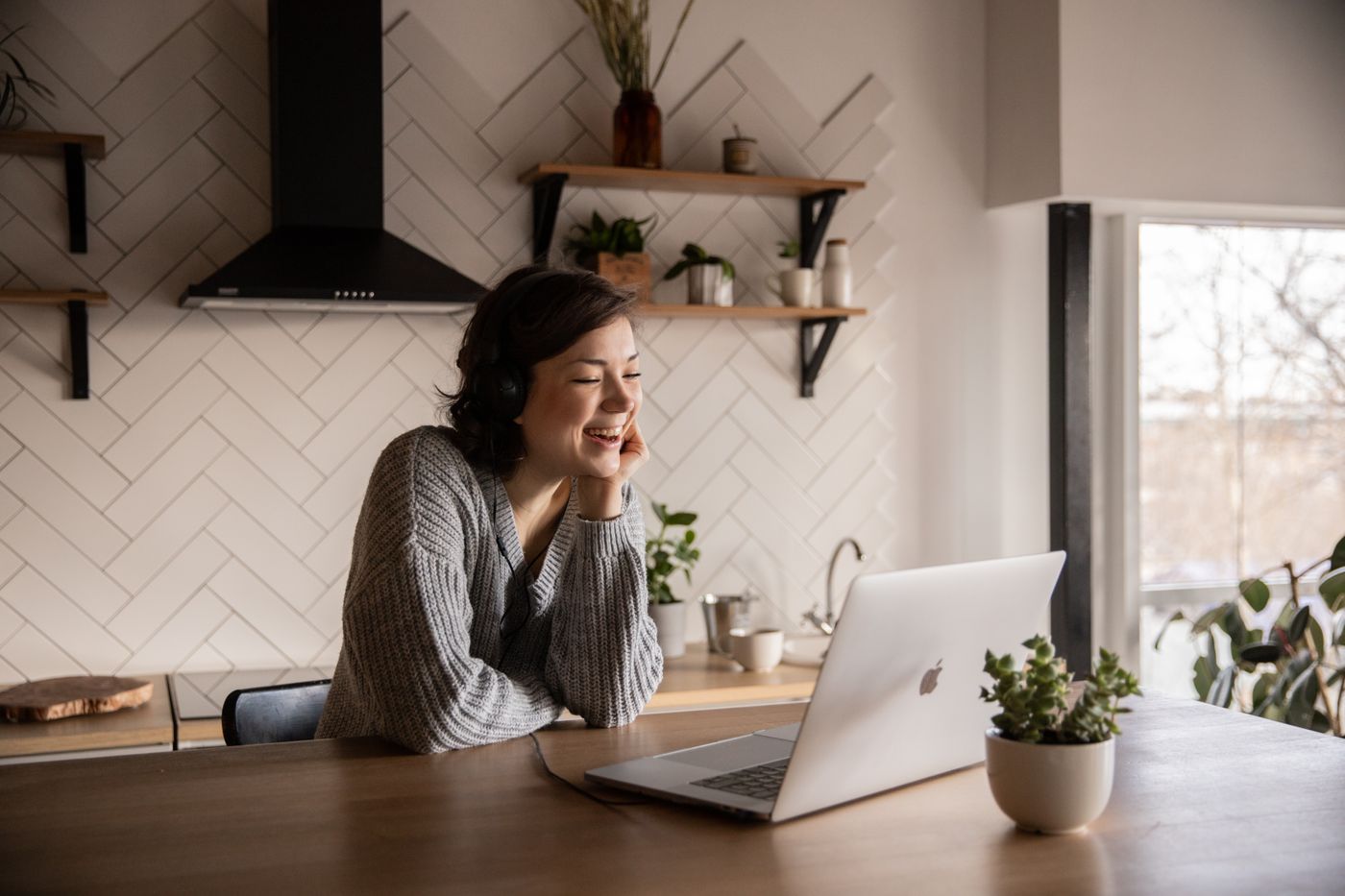 A woman smiling during a video consultation on her laptop at home